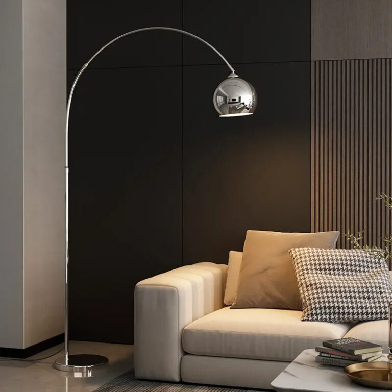 Grande lampe champignon chromée et ajustable de style minimaliste dans une pièce avec un canapé beige et des coussins