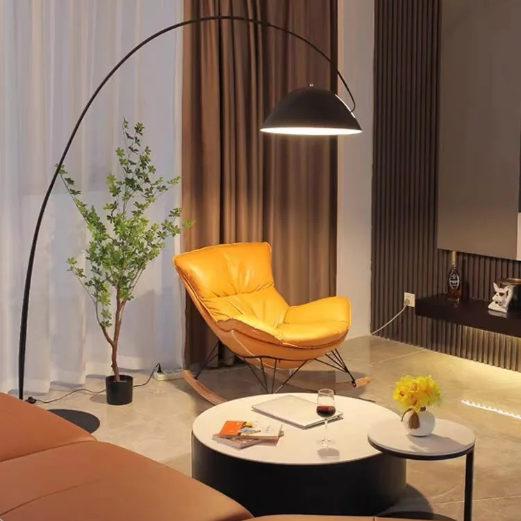 Grande lampe champignon noire de style moderne et minimaliste en fer dans uin salon avec un canapé une table ronde et un fauteuil orange sur fond de rideaux marrons