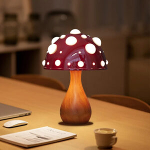 Lampe champignon LED rechargeable en métal sur une table en bois avec des objets