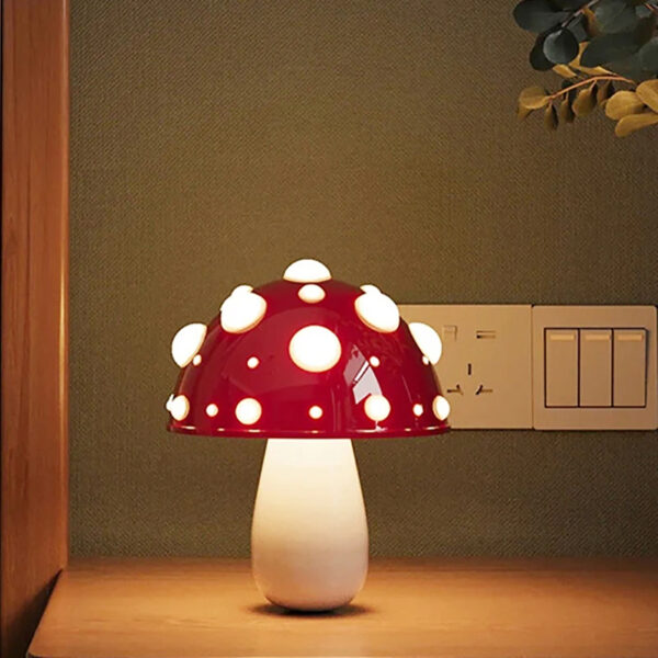 Lampe champignon LED rouge et rechargeable sur fond beige et gris