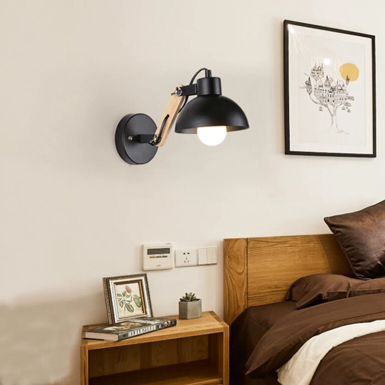 Lampe champignon murale en bois et fer sur un mur gris avec un tableau et un lit marron à droite