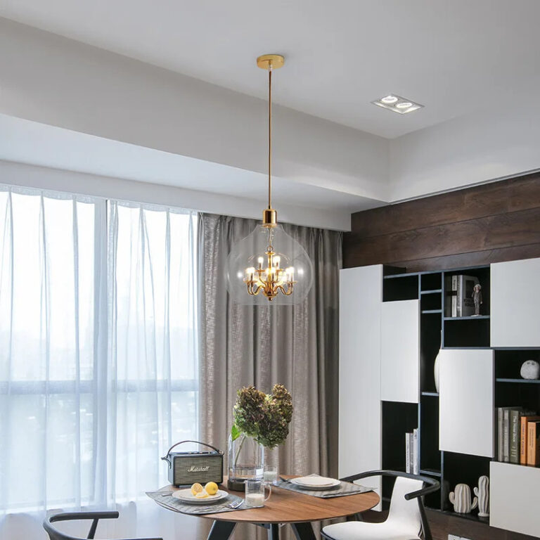 Lampe champignon verre soufflé dorée et suspendue de style lustre dans une pièce sur fond gris avec une table