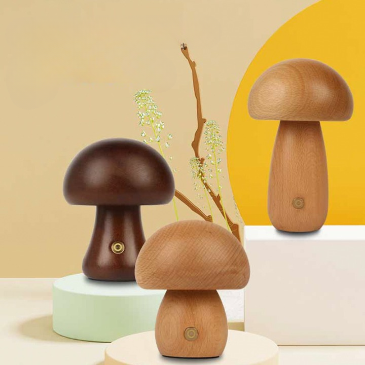 Trois lampes champignon posées sur des socles blancs. Le champignon de droite est plus haut et plus grand, le modèle de gauche est foncé, celui de devant est plus petit. Le fond est beige avec un arrondi jaune sur la droite.