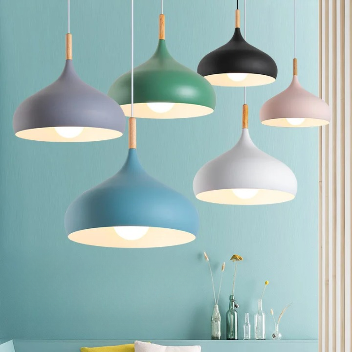 Six suspensions style scandinave fixées en 2 rangées. Celle du fond comprend de gauche à droite les couleurs grise, verte, noire et celle de devant : bleu, blanc, beige. Le mur derrière est vert. Les ampoules sont allumées.