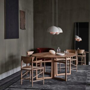 Salle à manger avec une table et des chaises en bois, des murs gris et deux luminaires blancs suspendus