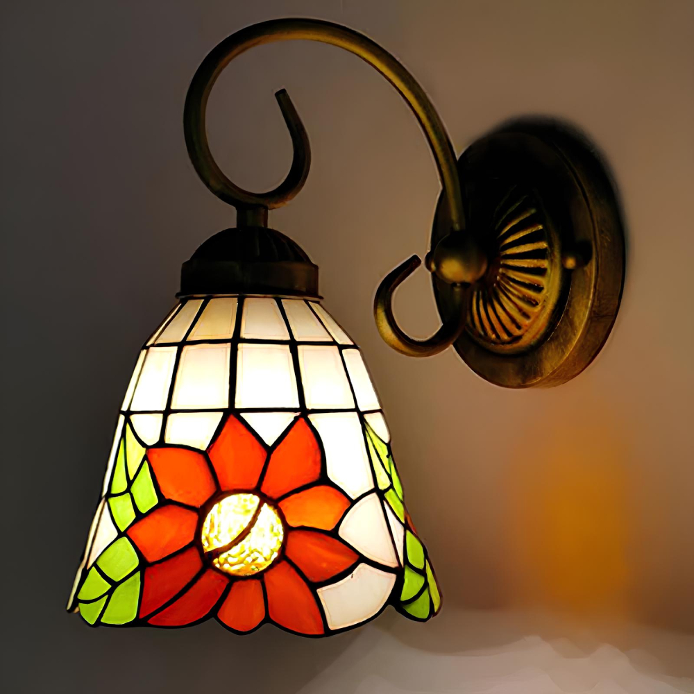 Lampe murale champignon de style tiffany avec des motifs floraux. La lampe est allumée. Sa fixation au mur est en métal.