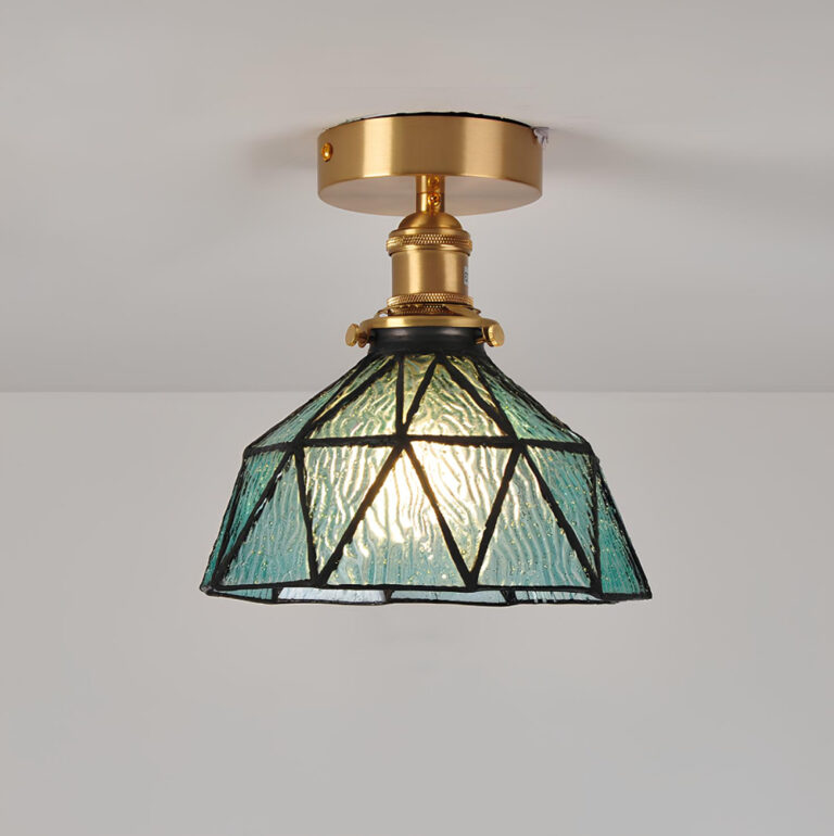 Plafonnier champignon avec fixation dorée et abat-jour en verre bleu de style Tiffany avec des lignes noires. L'ampoule est allumée.