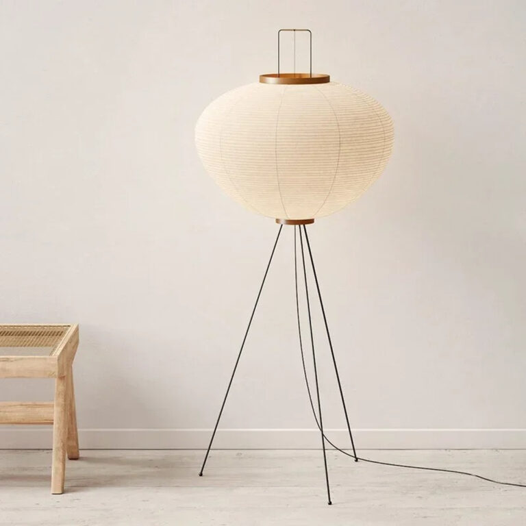 Lampadaire champignon japandi wabi sabi blanc en papier de riz sur son trépied métallique noir mit en valeur sur fond uni.
